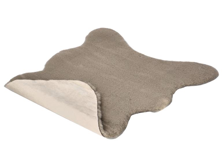 Tapis gris en fausse peau de mouton avec un bord plié montrant le dessous clair.