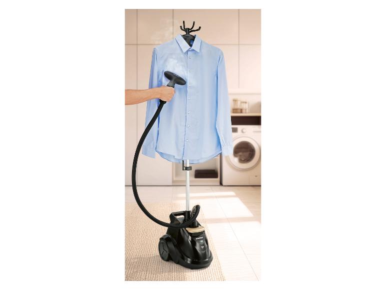 Homme défroissant une chemise bleue avec un défroisseur vapeur dans une buanderie.