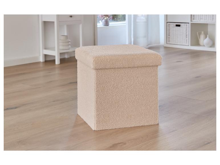 Un coffre de rangement en peluche beige sur un sol en bois.