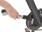 Nettoyage d'une chaîne de vélo avec une brosse.