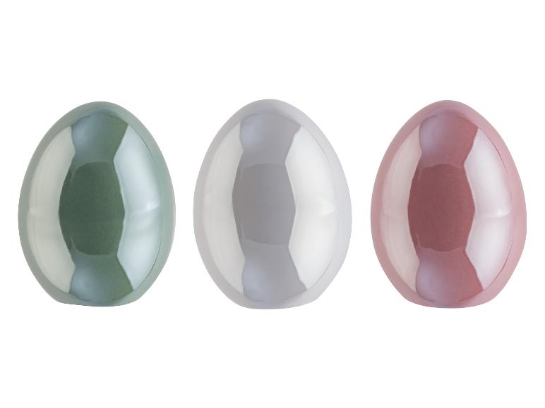 Trois œufs brillants de couleur pastel.