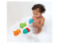 Bébé joue avec des jouets de bain : grenouille, tortue et poulpe.