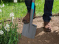 Une personne travaillant dans le jardin avec une pelle.
