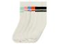 Quatre paires de chaussettes blanches avec des rayures colorées.