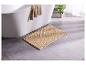 Un tapis de bain beige dans une salle de bain avec une baignoire.