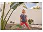 Fille en t-shirt fraise et legging rouge, debout dans un jardin.
