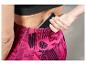 Une femme porte un legging de sport rose avec un smartphone dans la poche.