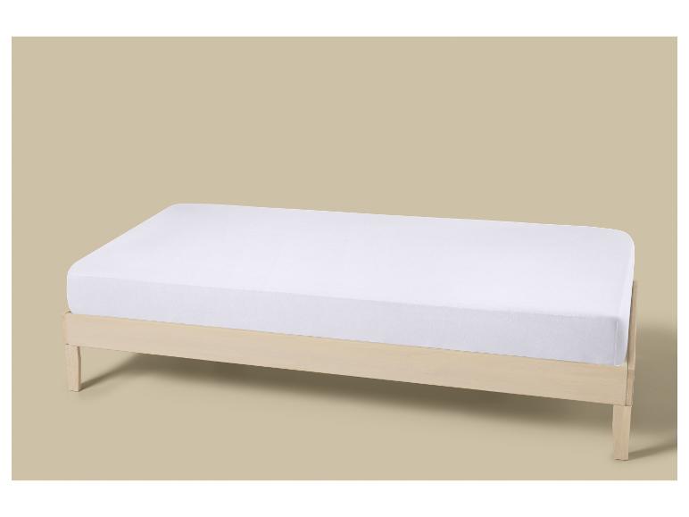 Lit simple en bois clair avec matelas blanc et drap-housse.