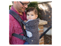 Un père porte son bébé dans une écharpe Infantino.