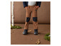 Pantalon marron avec genouillères et bottes noires.