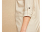 Gros plan d'une chemise beige avec des boutons.