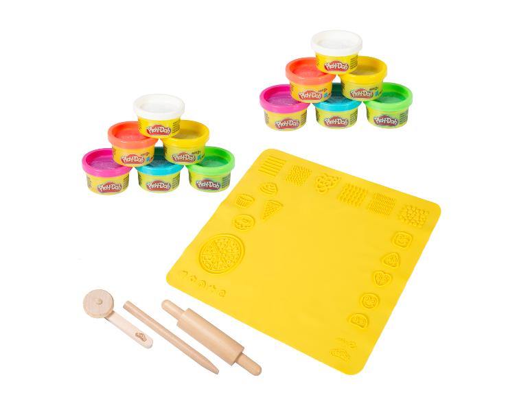Pots de pâte à modeler colorés, un tapis de jeu jaune avec des moules et des outils en bois.