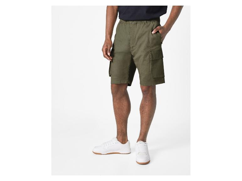Shorts cargo vert olive et baskets blanches.