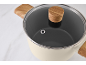 Casserole de couleur crème avec couvercle en verre et poignées aspect bois