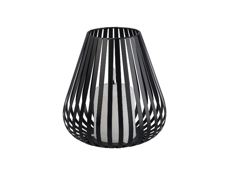 Un chandelier en métal noir avec une bougie blanche.