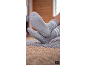 Pieds en chaussettes grises rayées avec semelles antidérapantes posés sur un tapis texturé.