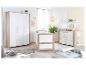 Chambre de bébé blanche et bois avec un lit à barreaux, une armoire et une table à langer.