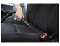 Une main utilisant un aspirateur pour nettoyer le siège d'une voiture.