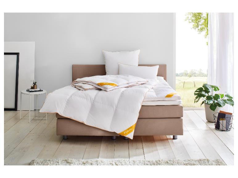 Couette et oreillers Palette Good Edition sur un lit dans une pièce lumineuse avec fenêtre.