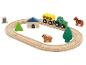 Ensemble de jouets en bois sur le thème de la ferme avec tracteur, wagon, animaux et rails.
