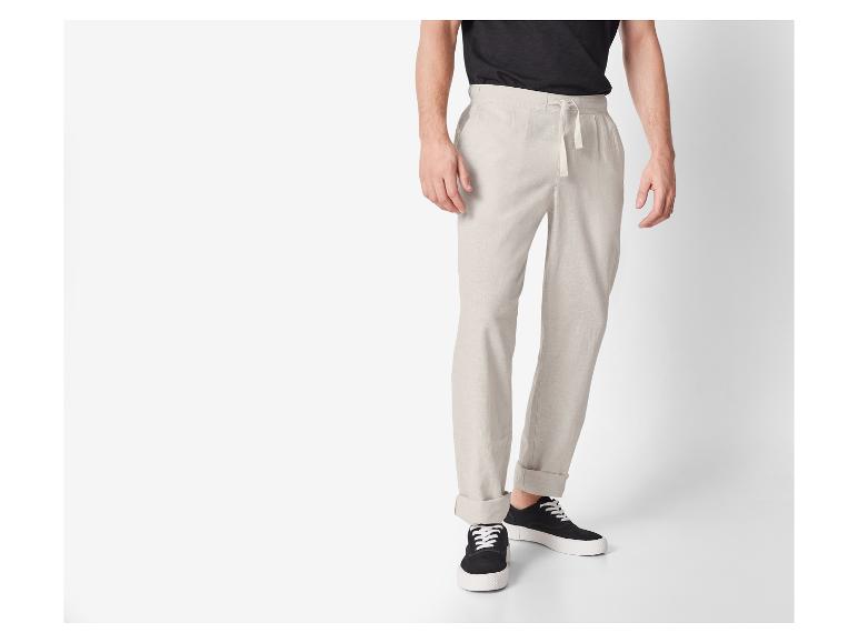 Pantalon lin beige et baskets noires : look décontracté.
