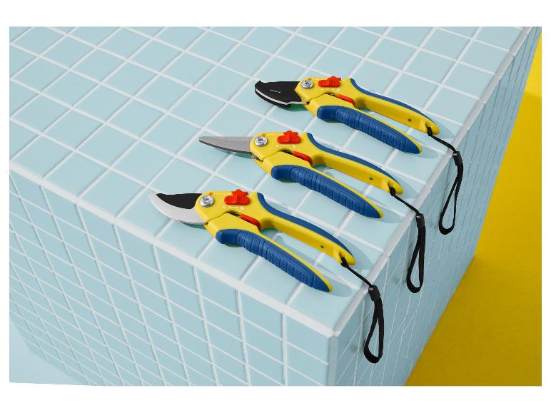 Trois sécateurs jaunes et bleus avec des dragonnes noires sur une surface carrelée bleu clair.