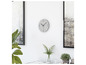 Une horloge murale blanche Mebus avec des aiguilles noires, deux œuvres d'art et des plantes vertes.