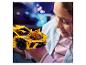 Une fille examine une voiture jaune en briques de construction.