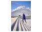 Homme en gilet de course bleu et leggings noirs montant des escaliers extérieurs.