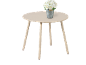 Table basse ronde beige avec un bouquet de roses blanches dans un seau en métal.