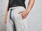 Un homme portant un pantalon de survêtement gris et un t-shirt noir.