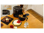 Une friteuse à air Tefal avec des muffins, des brownies, un cheesecake et une carafe d'eau sur une table en bois.