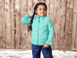 Une fille porte une veste en polaire bleue et un pantalon bleu dans la neige.