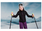 Une fille avec un équipement de ski dans la neige.
