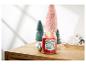 Une bougie Yankee Candle 'The Night Before Christmas' allumée sur une surface en bois avec des arbres décoratifs et des ornements.