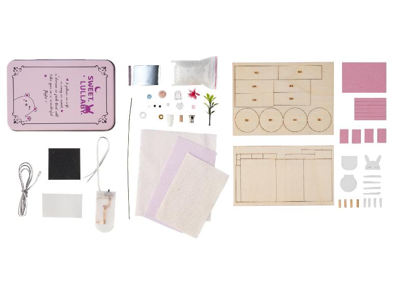 Kit de maison de poupée miniature DIY avec boîte rose, pièces en bois, tissu et petits accessoires.