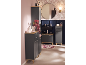Salle de bain avec meubles gris foncé et accents bois, mur rose et papier peint floral.