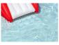 Matelas gonflable rouge et blanc flottant dans une piscine d'eau bleue.