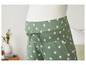 Pantalon de grossesse vert avec un motif de cœurs blancs.