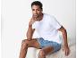 Un homme portant un t-shirt blanc et un short bleu à motifs.