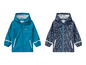 Deux imperméables pour enfants, un bleu avec un sous-marin et un bleu avec un motif de bateaux.