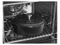 Marmite en fonte noire avec couvercle à l'intérieur d'un four sur une grille métallique