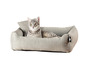 Un chat gris est dans un lit de chien gris.