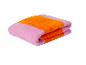 Serviettes de bain pliées, rose et orange.