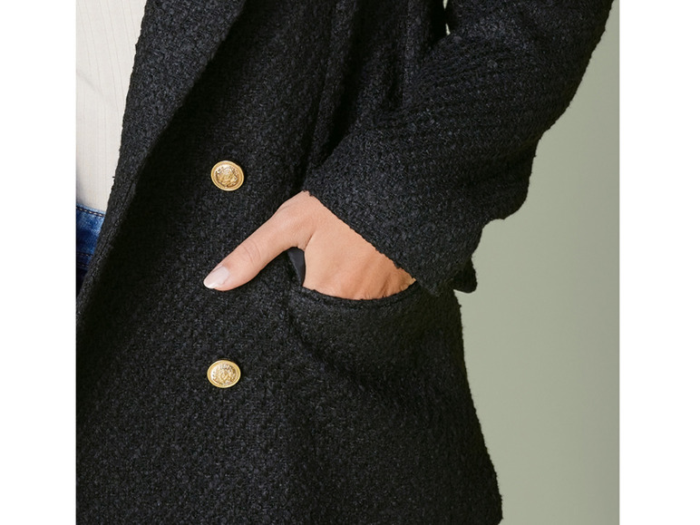 Un blazer noir avec des boutons dorés et une poche.