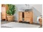 Meuble salle de bain en bois clair avec lavabo, rangements et tapis.