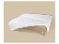 Couette blanche matelassée sur un lit à cadre en bois