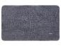 Tapis de bain gris foncé avec logo blanc et rouge dans le coin inférieur droit.
