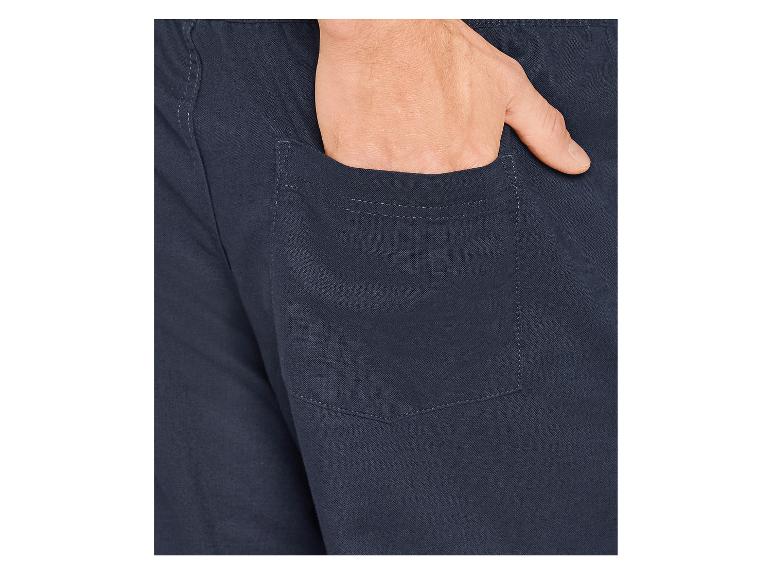 Gros plan d'une main dans la poche d'un pantalon bleu foncé.