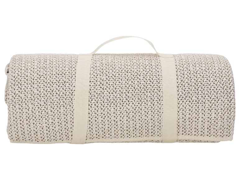 Tapis de plage roulé beige avec poignée.